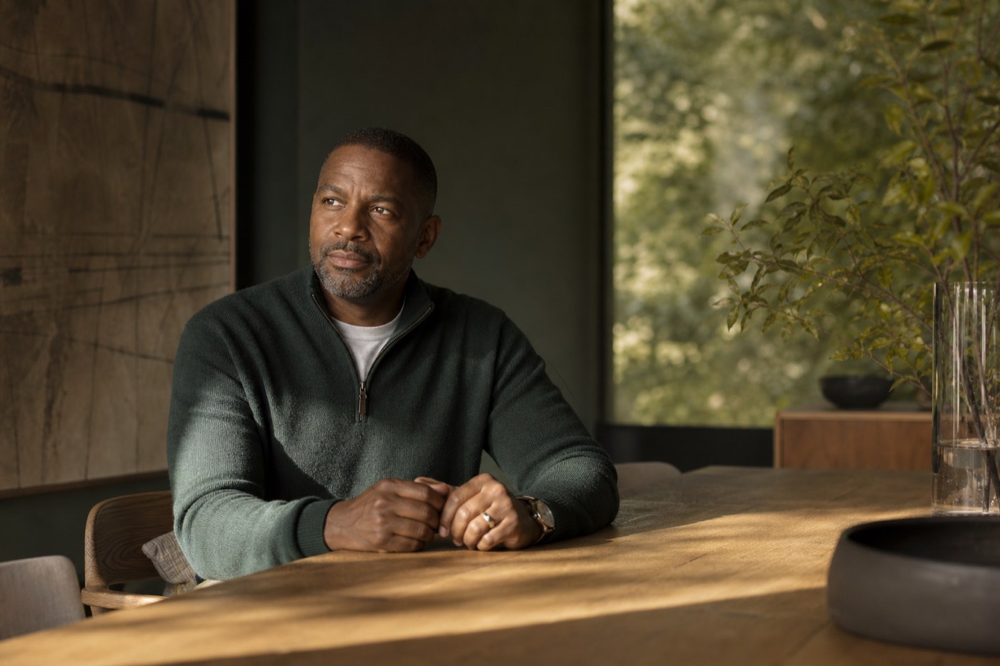 Daniel Okafor seated at a long oak table in soft window light